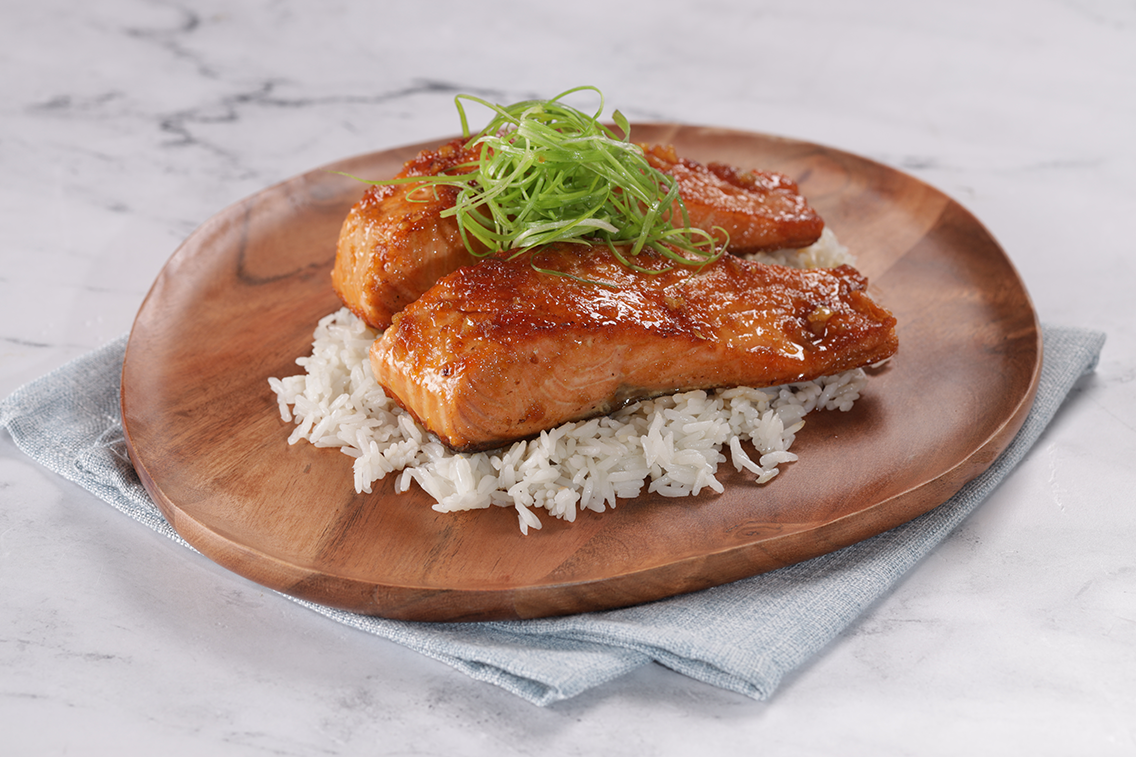 Salmone caramellato con riso bianco e guarnizione di erba cipollina.