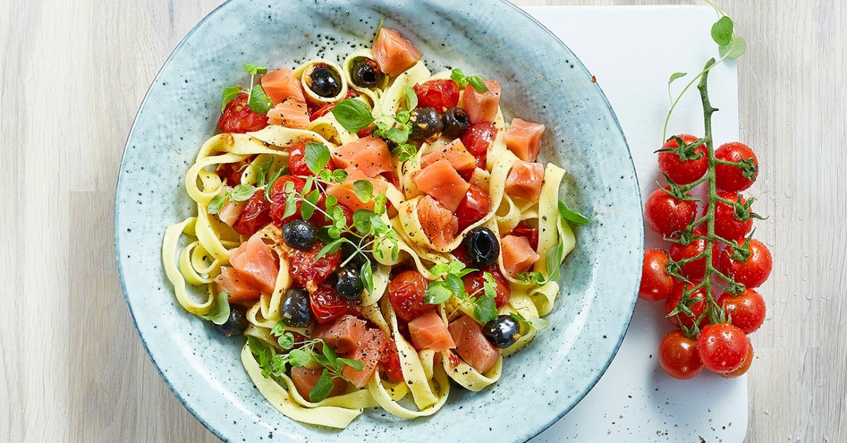 Pasta fresca con salmone, pomodorini, olive nere e erbe aromatiche.