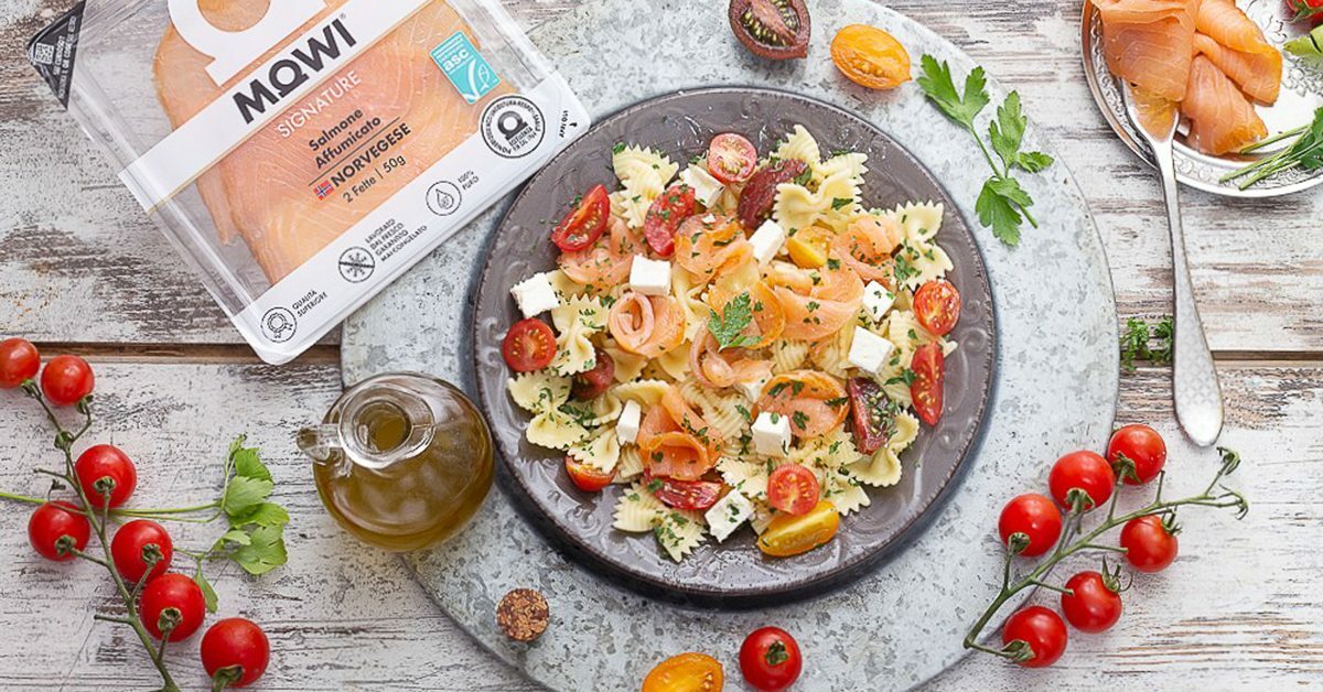 Insalata di pasta Farfalle con salmone affumicato, pomodorini e cubetti di formaggio.