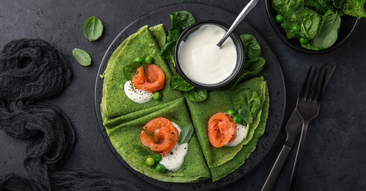 Crêpes verdi al salmone affumicato con panna acida e piselli.