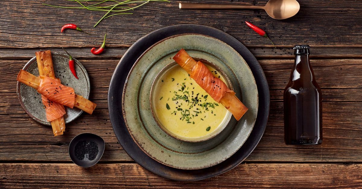 Zuppa cremosa con salmone affumicato avvolto in pasta croccante e spezie.