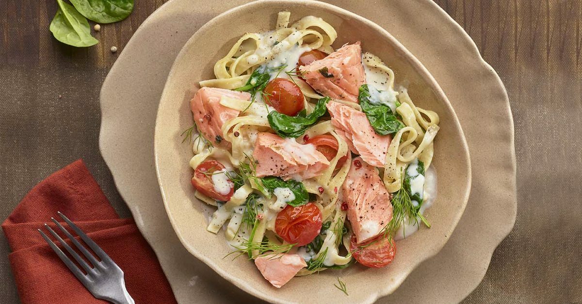 Tagliatelle al salmone, pomodorini e spinaci in salsa cremosa.