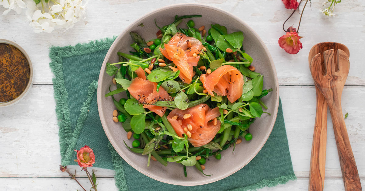 Insalata primaverile con salmone affumicato, piselli, fagiolini e pinoli.