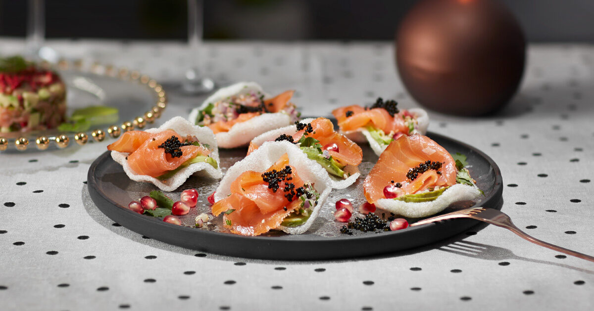 Appetizer di salmone affumicato su cialde croccanti con caviale e semi di melograno.