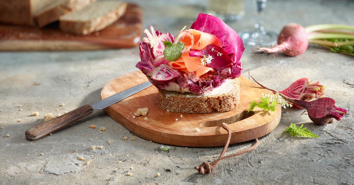 Tramezzino colorato con salmone, radicchio, ravanelli e pane integrale.