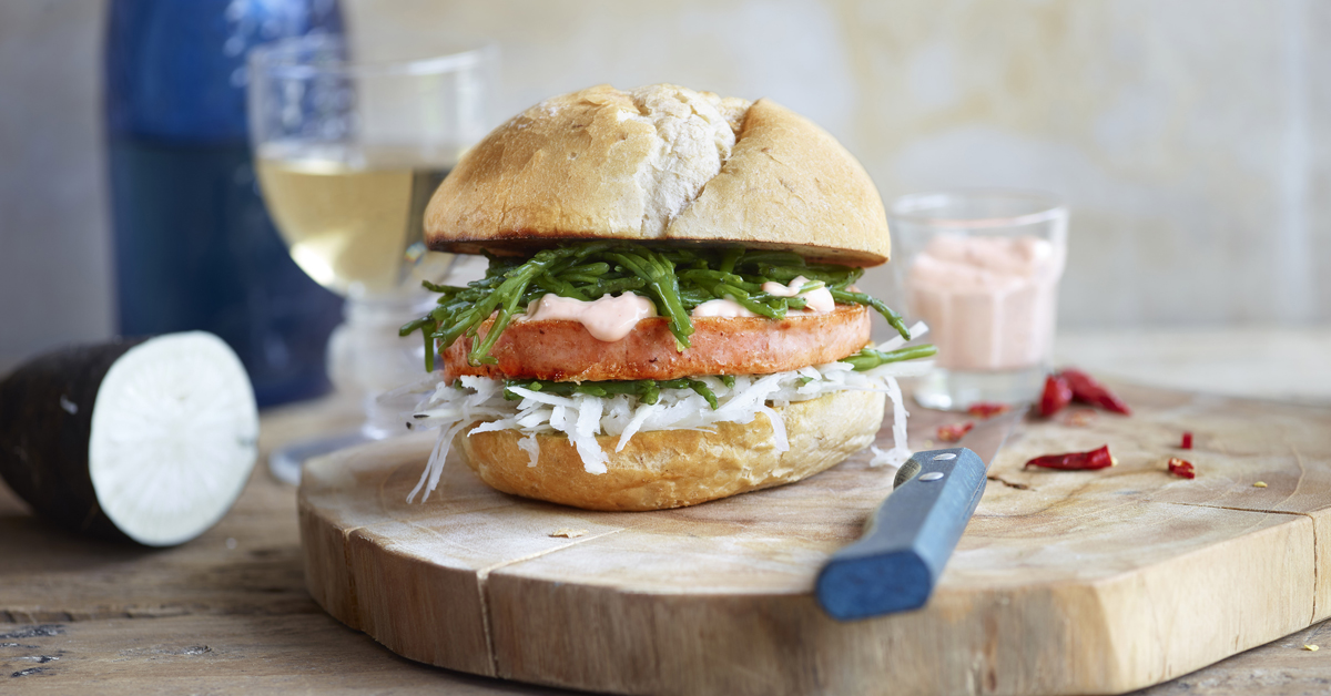 Panino con fetta spessa di salume, salicornia, rafano e maionese rosa.