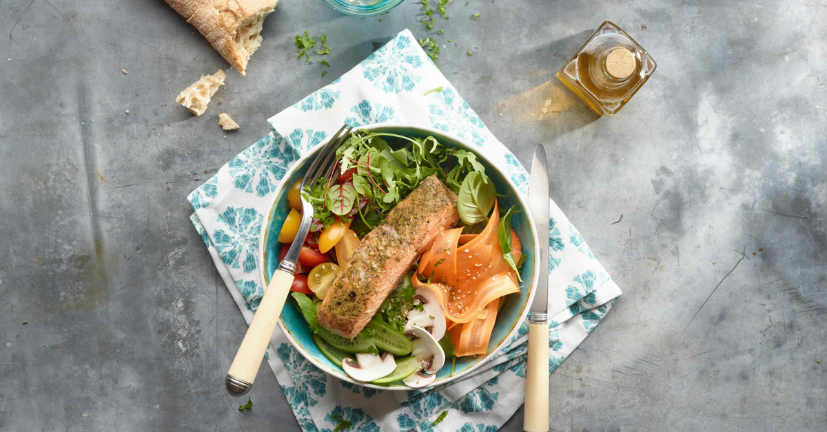 Insalata con salmone, pomodorini, cetrioli, carote, funghi e pane.