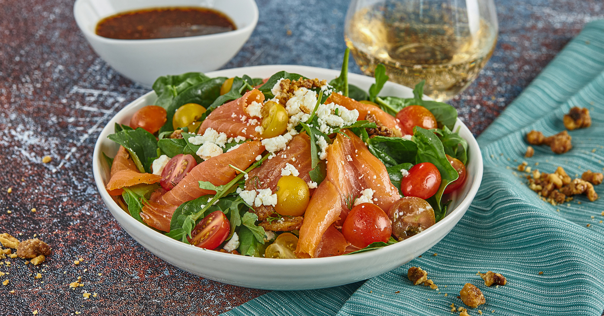 Insalata con salmone affumicato, pomodorini, formaggio sbriciolato e noci.